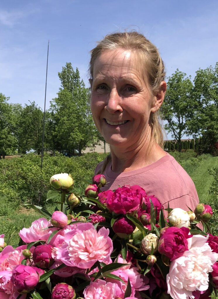 Chris holding peonies in garden