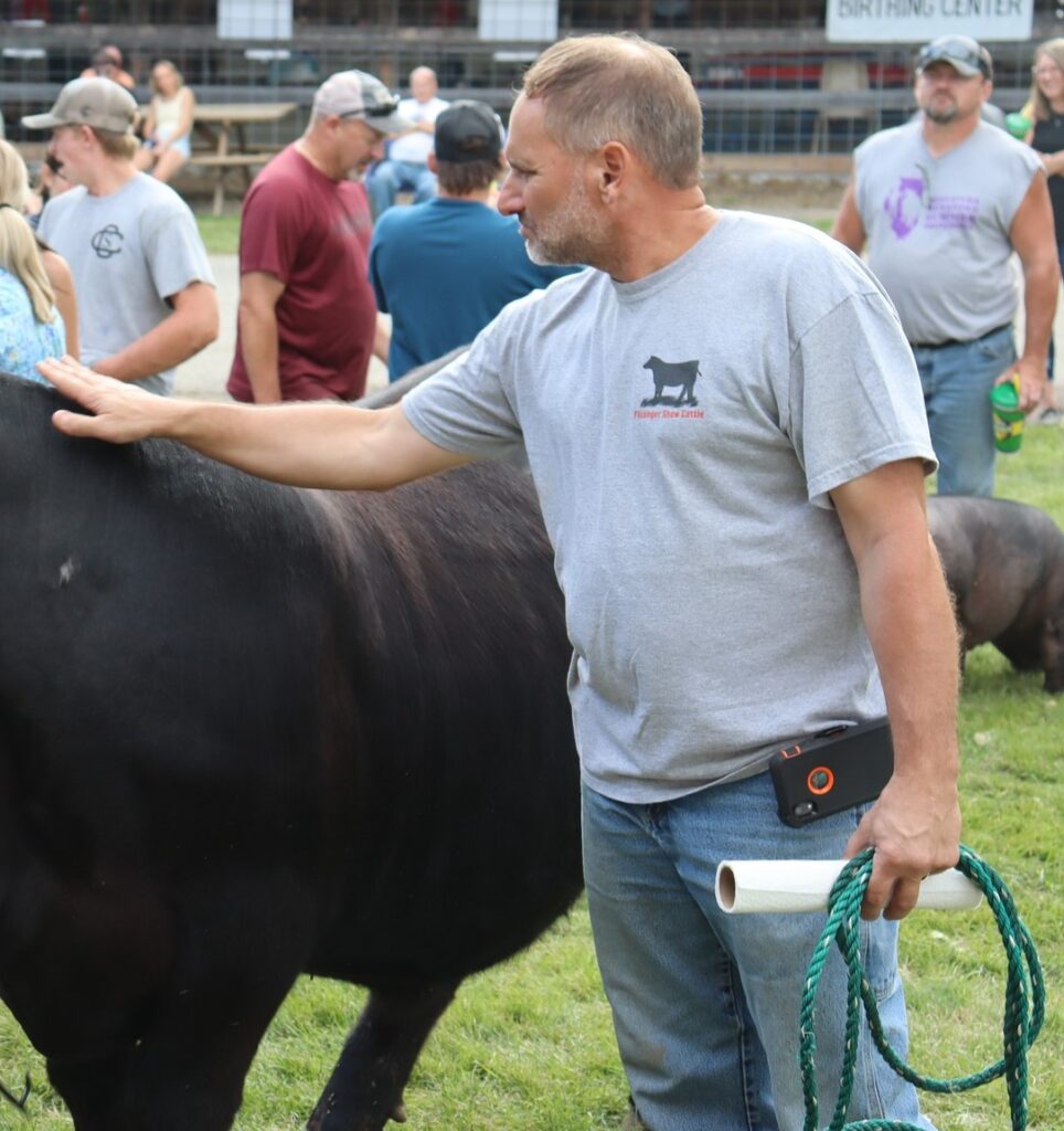 Jason Flickinger patting a big angus