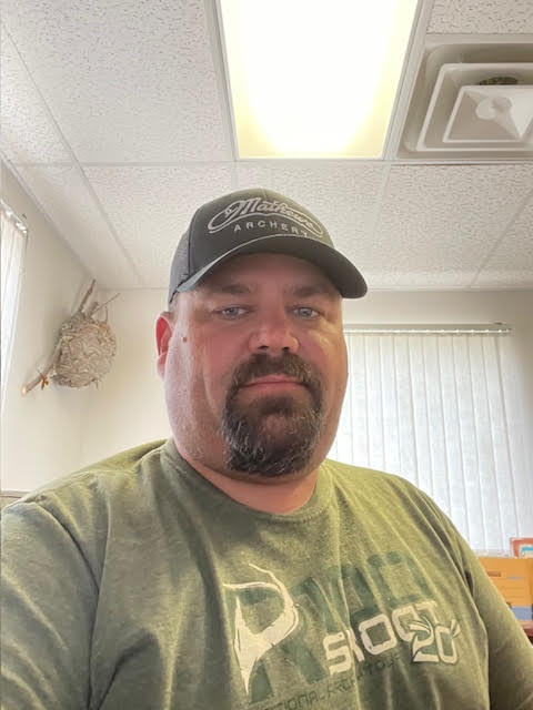 Wyatt with a go tee, green shirt and green baseball cap.