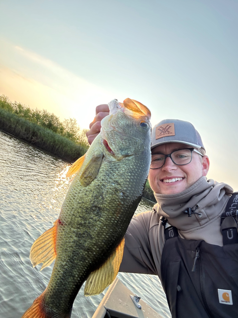 Ben Ford smiling while holding a very big largemouth bass.