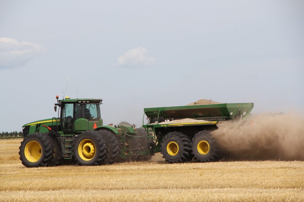 John Deere combine pulling a trailer fill of grain